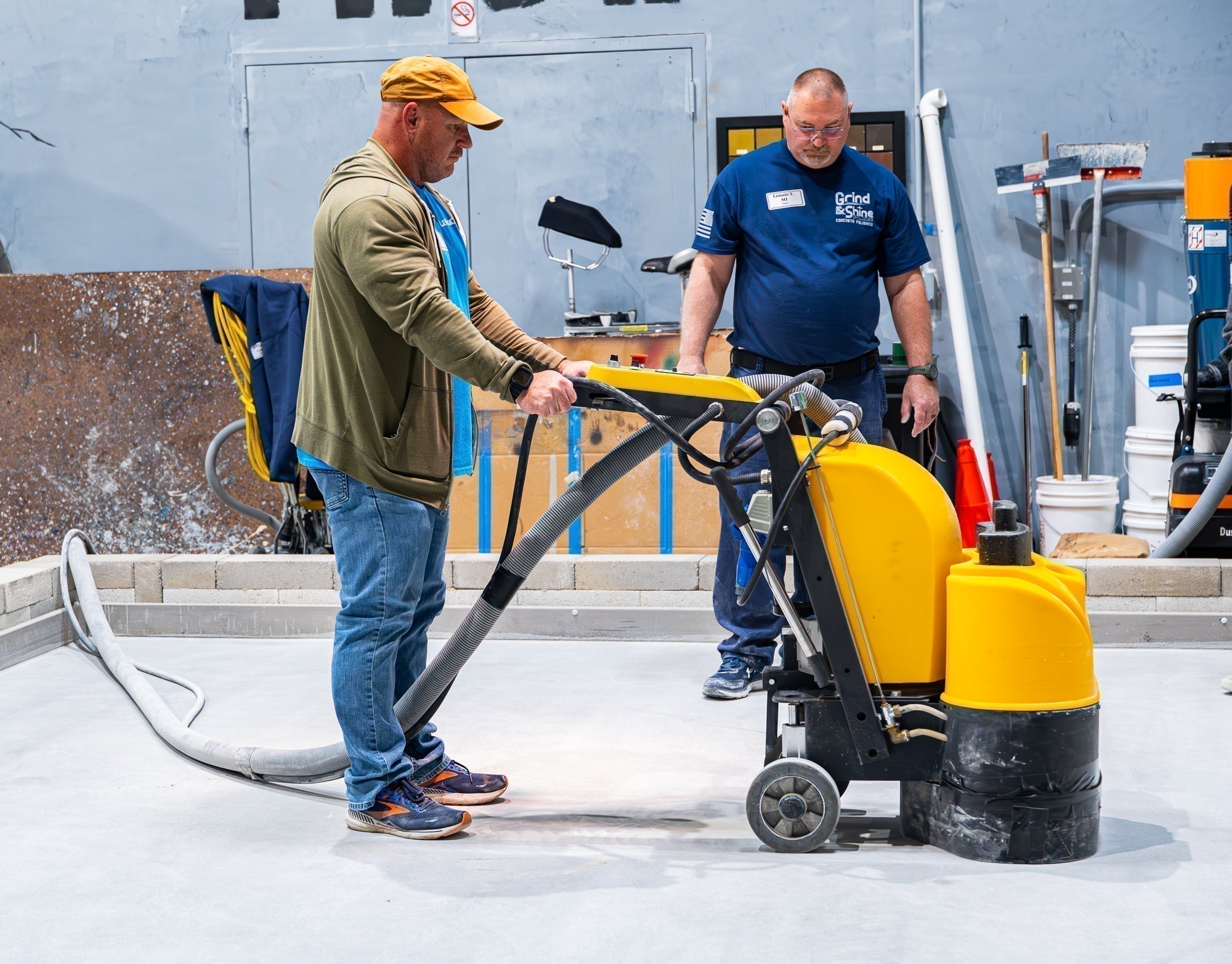 Epoxy resin contractors learning how to use a flooring grinder with XPS burnishing pads on-site at Epoxy Classes.