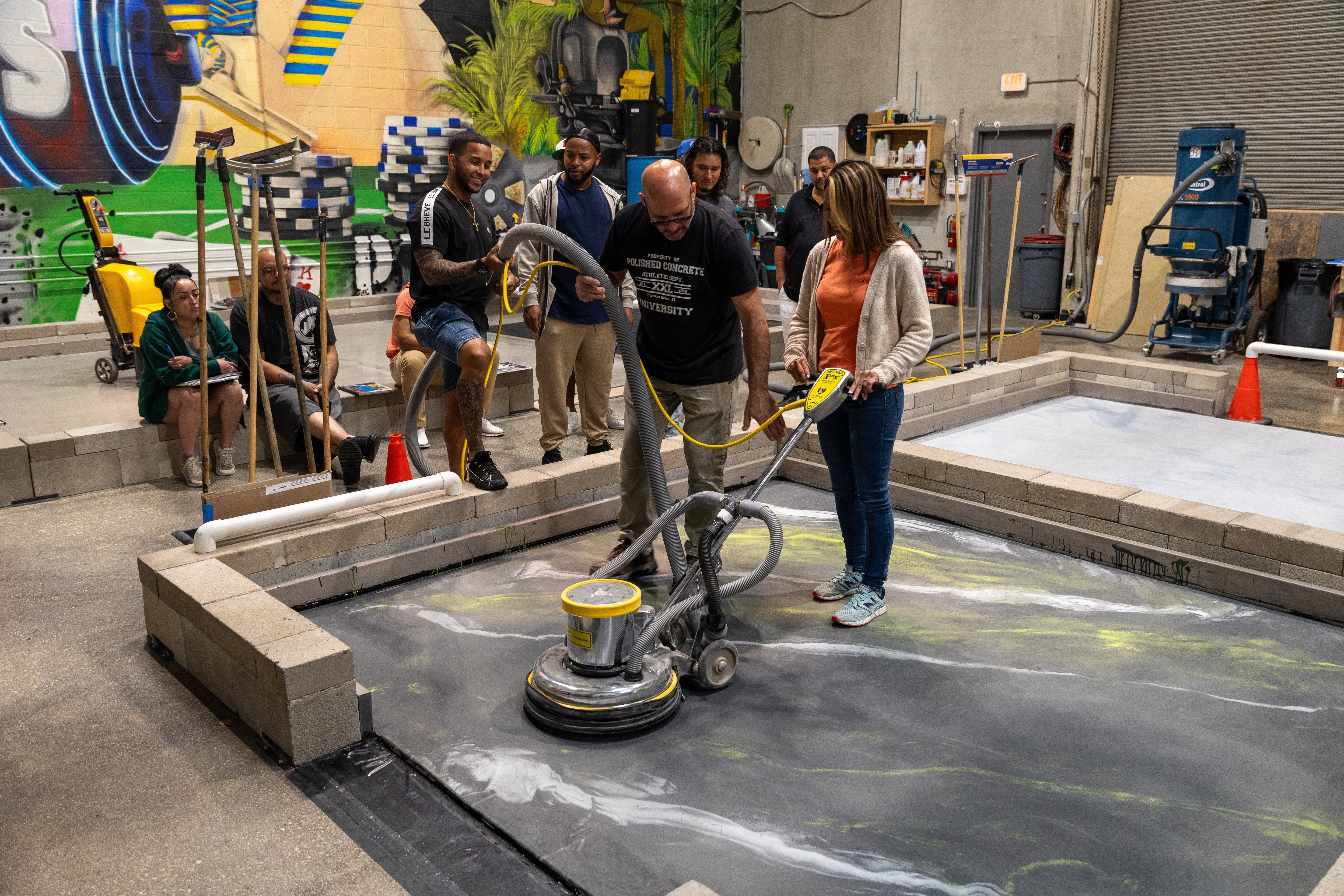 A concrete grinder training class student learning how to operate a concrete polishing machine.