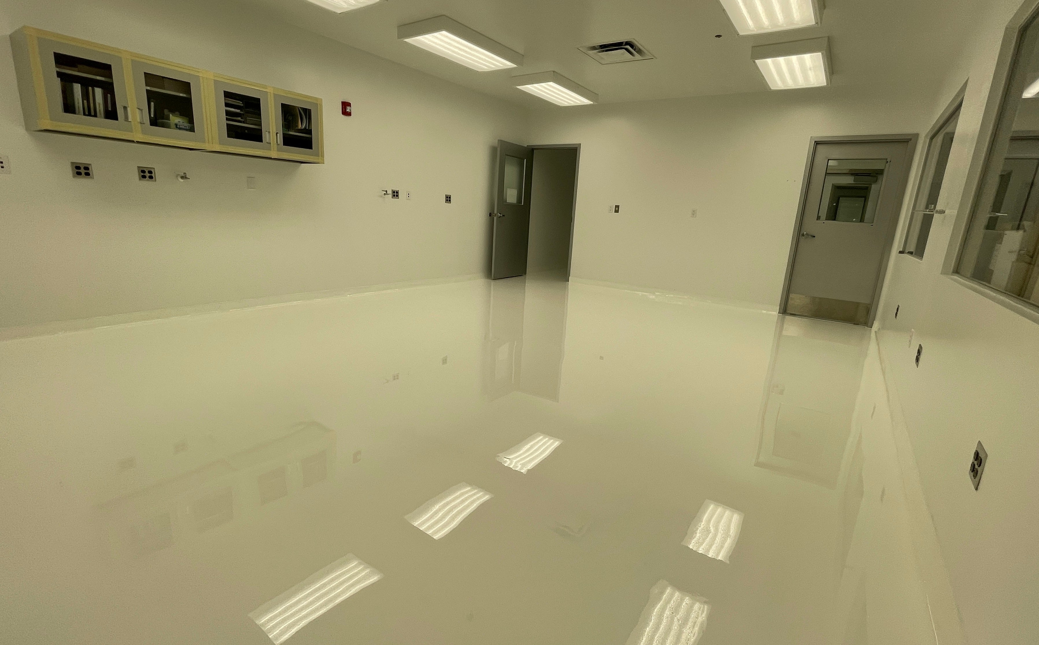 A resinous coating flooring system in a sterile white commercial space.