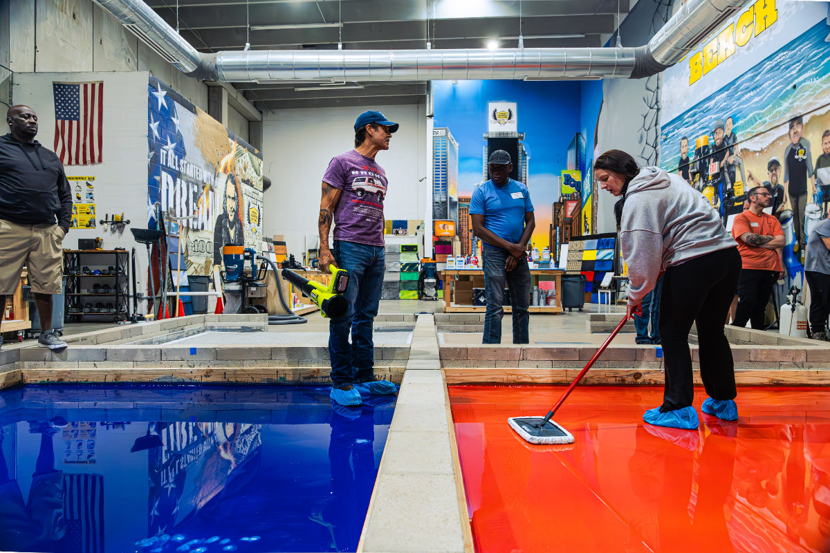 Students applying epoxy coatings to an epoxy floor in class setting
