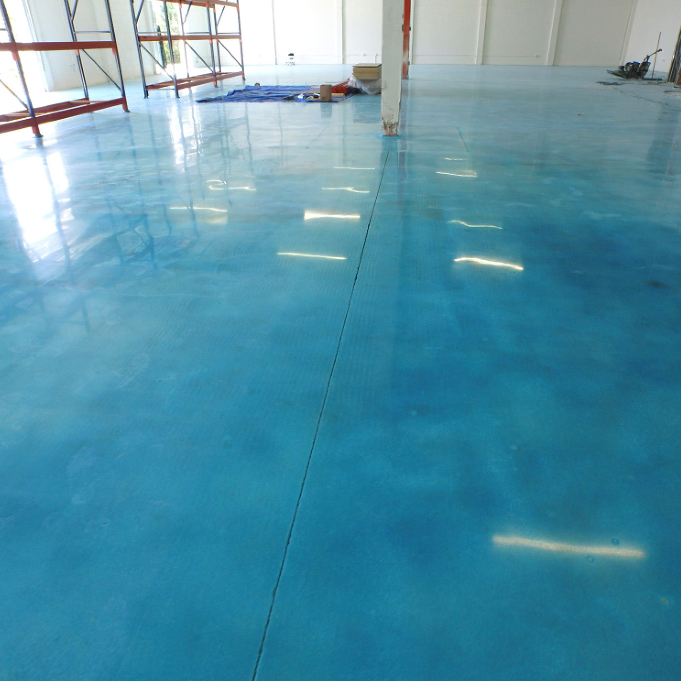 Blue epoxy floor in large interior space | XPS - xtreme polishing systems, chantilly flooring, polishing store, flooring supplies, and concrete floor shop. Epoxy stores.