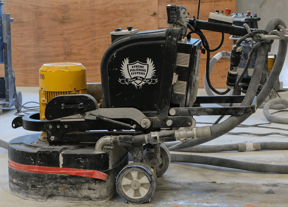 A medium-size concrete floor grinder with diamond tips distributed by Xtreme Polishing Systems.