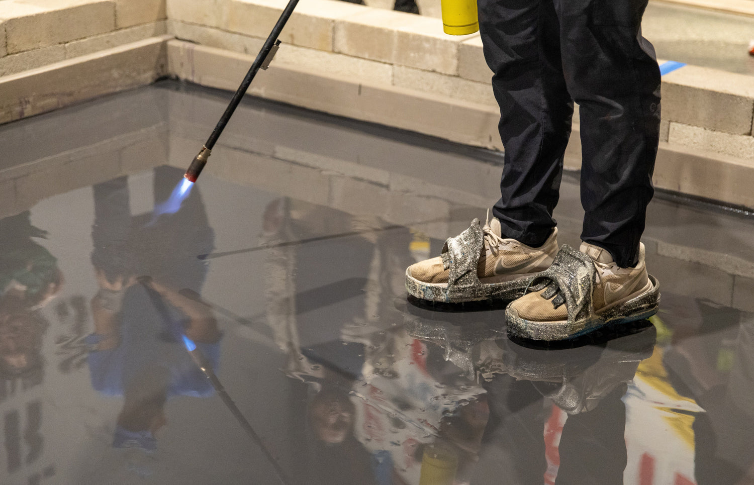 An epoxy resin contractor in an Epoxy Classes certification course using a blowtorch to get rid of bubbles in epoxy resin curing.