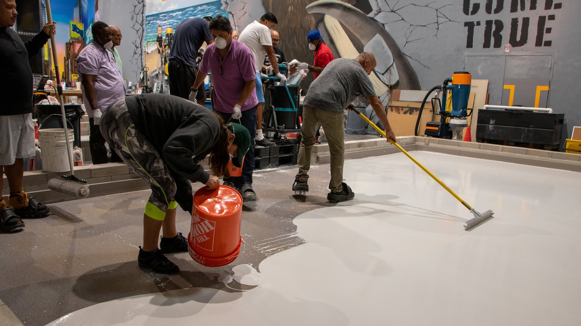 A group of epoxy resin contractors fixing concrete moisture before an epoxy resin installation.