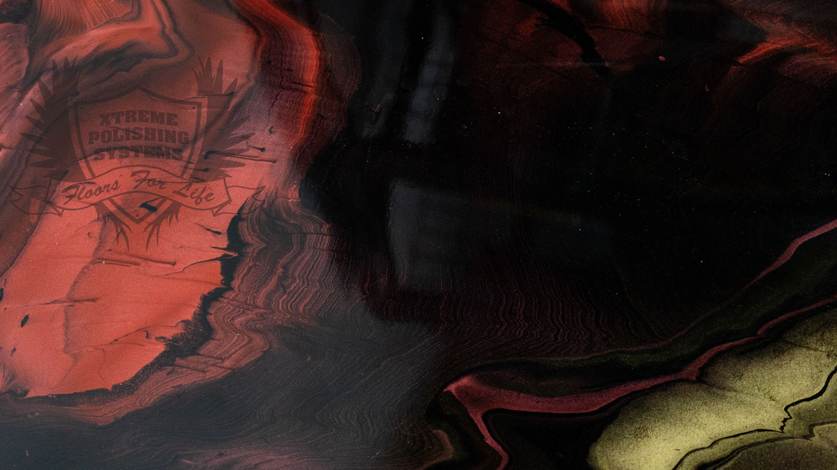 A metallic epoxy resin sample in red, black and gold colors.