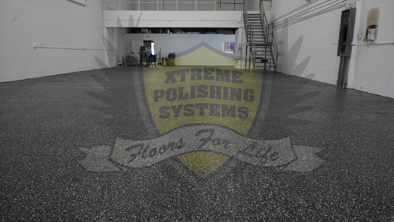 An epoxy resin flake flooring project installation in a commercial warehouse setting.