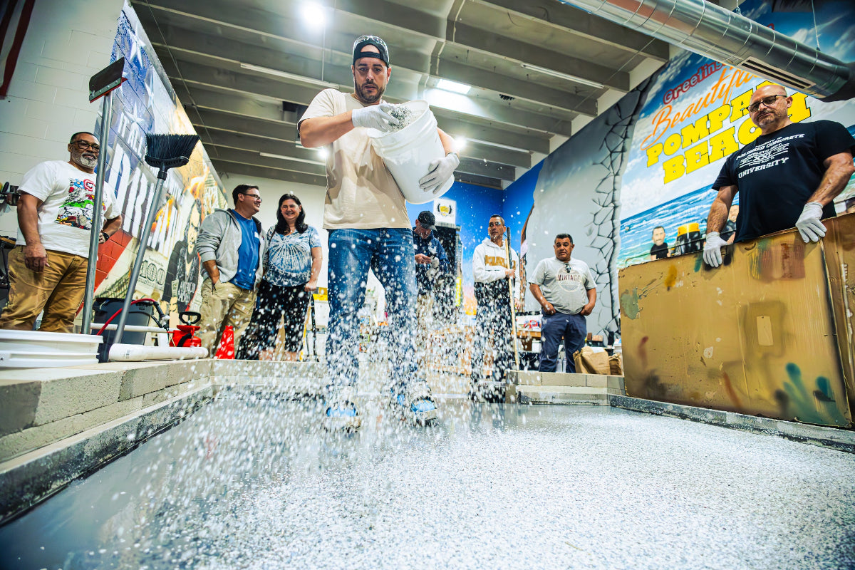 Student applying epoxy flake to flooring in class