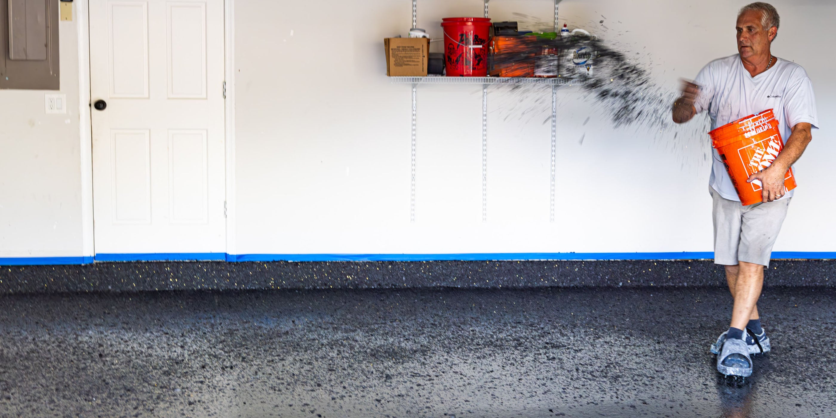 Epoxy flake being thrown onto an epoxy garage floor.