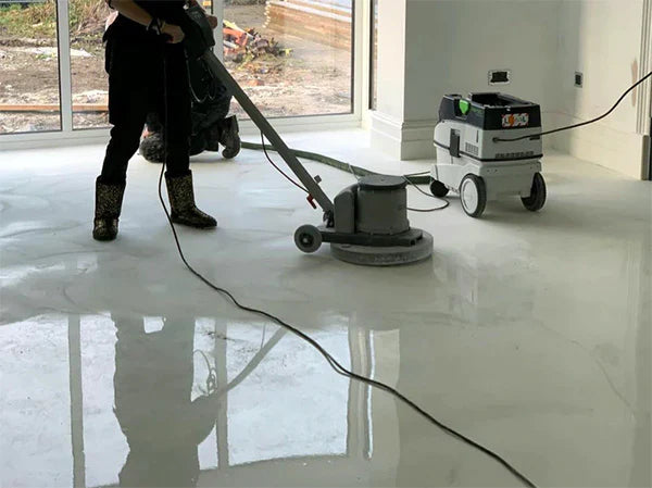 Man polishing white and gray epoxy floor inside home with floor polishing machines